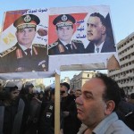 A supporter of Egypt’s army chief General al-Sisi holds poster of al-Sisi and former president Nasser, after bomb attack in Cairo