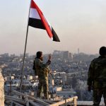 un-soldado-del-ejercito-de-al-assad-hace-el-gesto-de-la-victoria-bajo-una-bandera-siria-en-el-barrio-de-al-sakhour-en-alepo-reuters